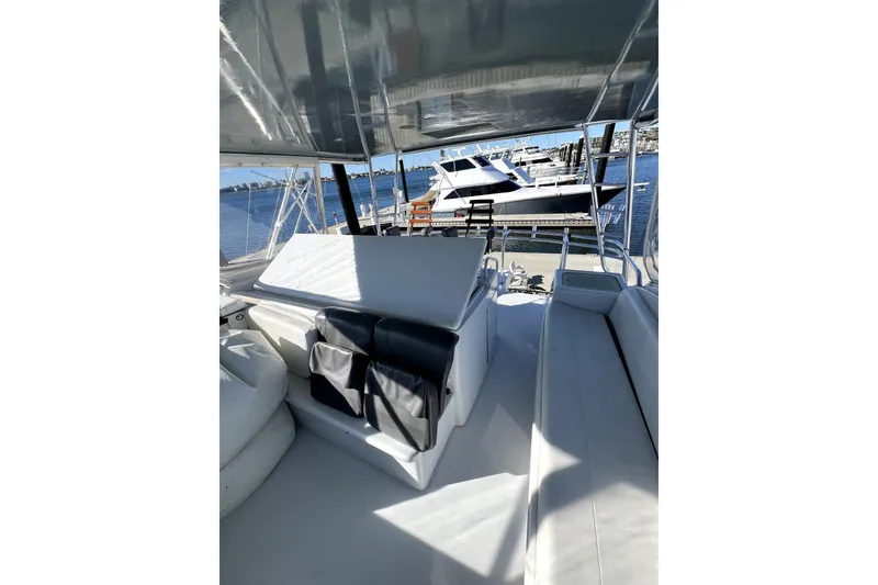Slide: The Image of 2003 Hatteras 60 Convertible yacht interior with seating, docked at marina. - 78