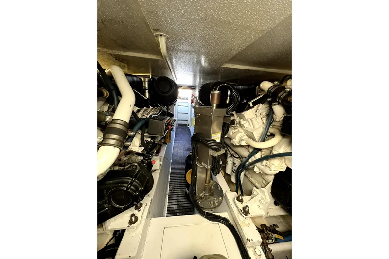 Slide: The Image of Engine room of 2003 Hatteras 60 Convertible yacht, showcasing mechanical components and piping. - 82