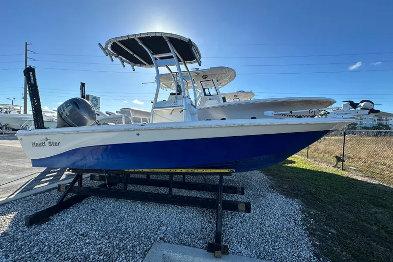 The Image of 2015 NauticStar 1810 NauticBay boat on display, blue hull, parked on gravel. - 1