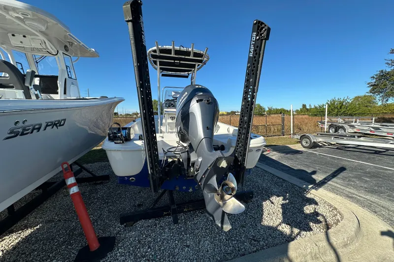 Slide: The Image of 2015 NauticStar 1810 NauticBay boat with outboard motor, parked on gravel. - 4