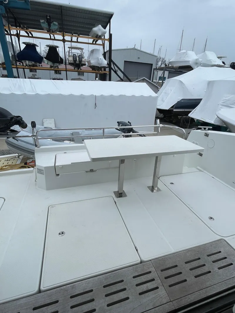 Slide: The Image of 2018 Fountaine Pajot MY 37 yacht deck with seating and table, docked in a marina. - 28