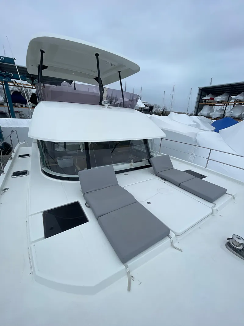 Slide: The Image of 2018 Fountaine Pajot MY 37 yacht with sun loungers on deck, docked in a marina. - 33