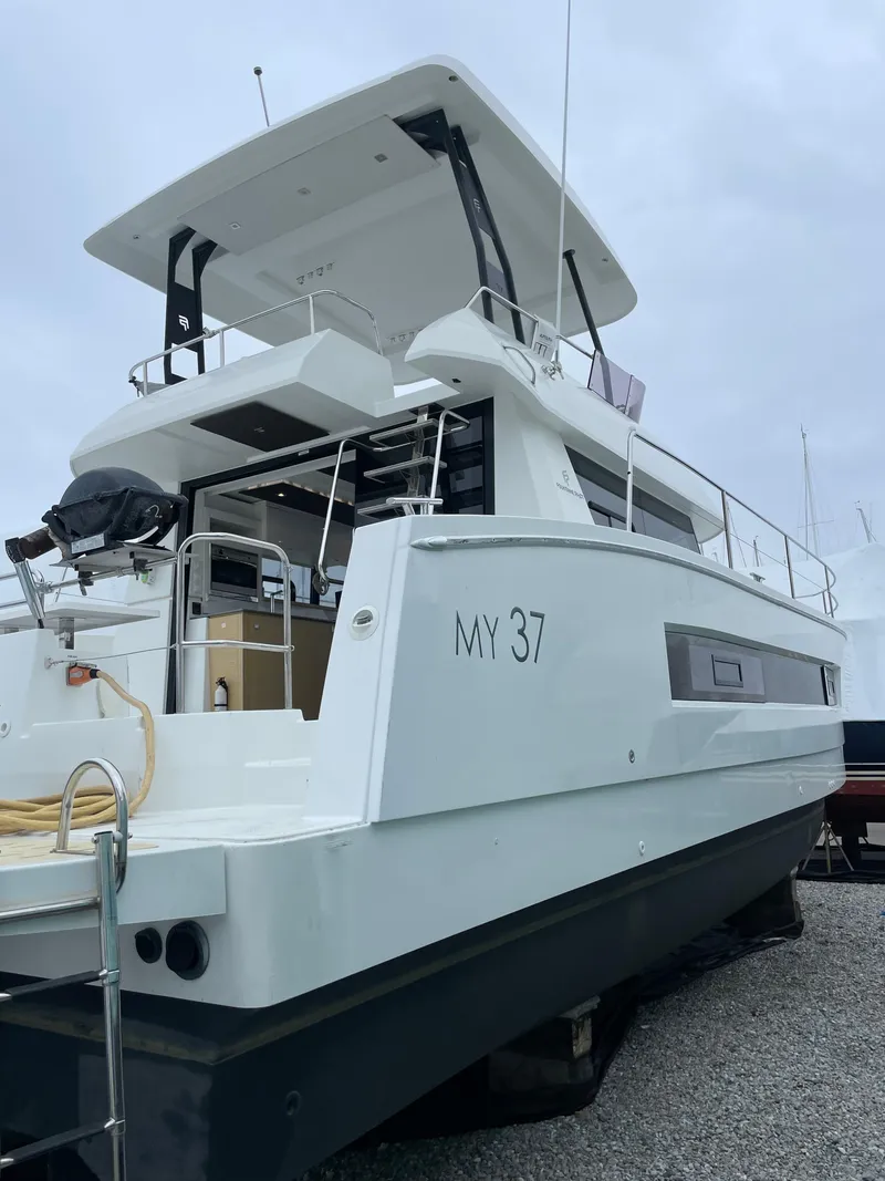Slide: The Image of 2018 Fountaine Pajot MY 37 yacht, docked, showcasing sleek design and spacious deck. - 5