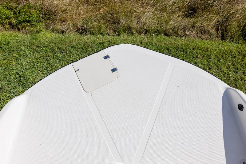 Slide: The Image of Bow of 2008 Key West 210 LS boat on grass, showing hatch and textured surface. - 11