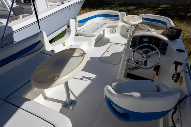 Slide: The Image of 2008 Key West 210 LS boat interior with seating, steering wheel, and tables. - 5
