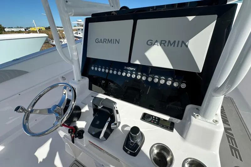 Slide: The Image of 2026 Twin Vee 340 GFX CC boat dashboard with Garmin displays and steering wheel. - 7