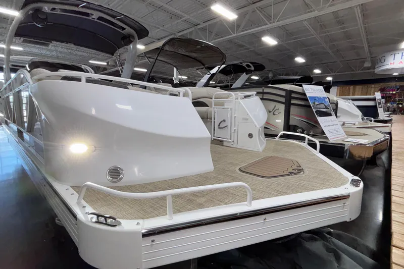 The Image of 2026 JC Sporttoon 26TT pontoon boat displayed indoors at a showroom. - 1