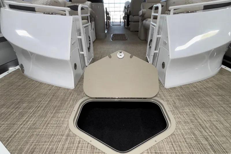 Slide: The Image of 2026 JC Sporttoon 26TT boat interior with open storage compartment on carpeted floor. - 12