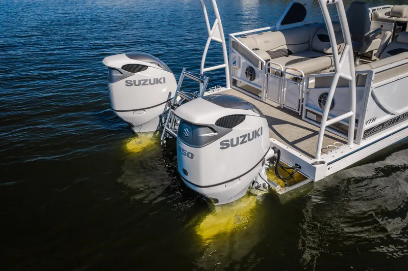 Slide: The Image of 2026 JC Sporttoon 26TT pontoon boat with dual Suzuki outboard motors on water. - 4