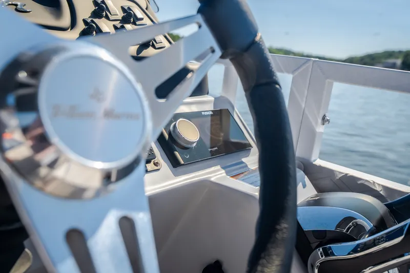 Slide: The Image of Steering wheel and dashboard of 2026 JC Sporttoon 26TT boat on water. - 40