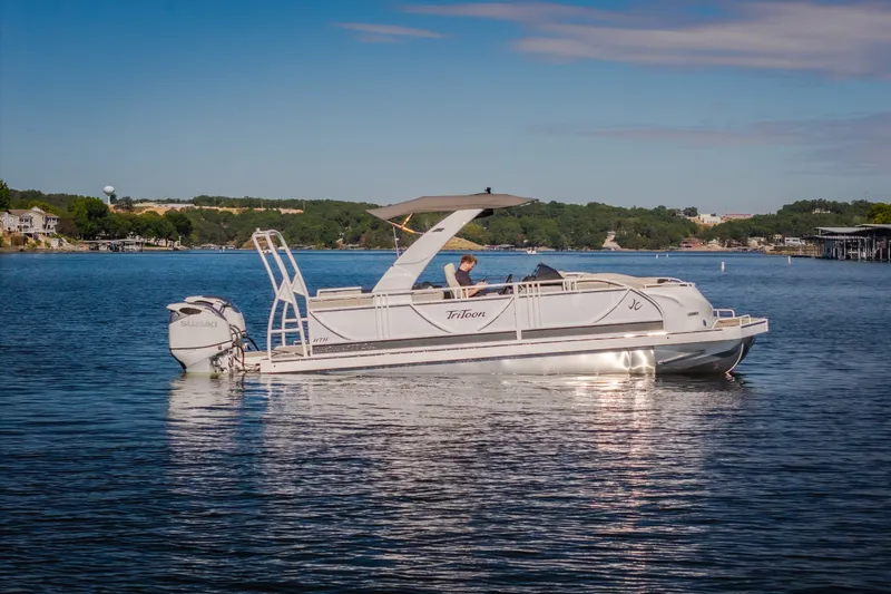 Slide: The Image of 2026 JC Sporttoon 26TT pontoon boat on a serene lake with scenic background. - 59