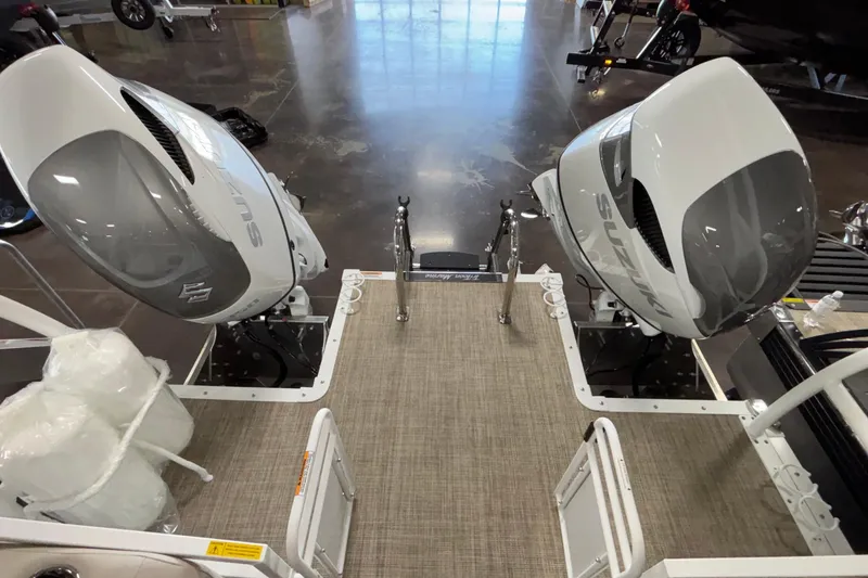 Slide: The Image of 2026 JC Sporttoon 26TT boat with dual Suzuki outboard motors in showroom. - 24