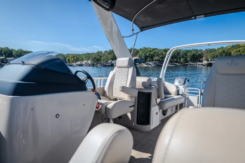 Slide: The Image of 2026 JC Sporttoon 26TT pontoon boat interior with luxurious seating on a sunny lake. - 23
