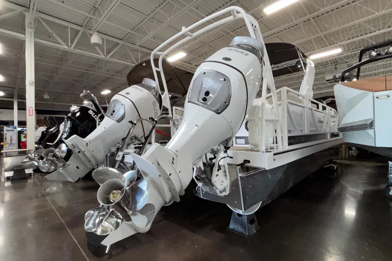 Slide: The Image of 2026 JC Sporttoon 26TT pontoon boat with dual outboard motors in a showroom. - 4