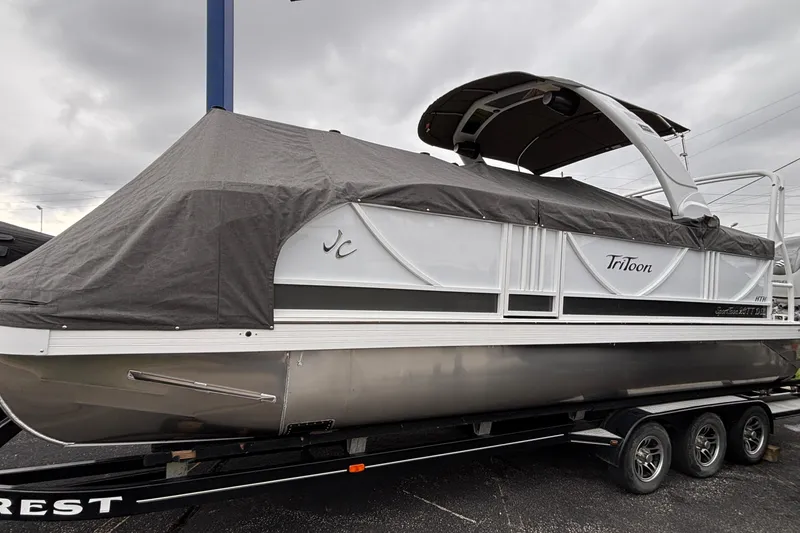 Slide: The Image of 2026 JC Sporttoon 26TT pontoon boat with cover on trailer, under cloudy sky. - 42
