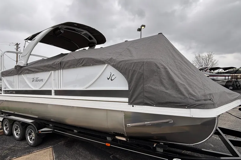 Slide: The Image of 2026 JC Sporttoon 26TT pontoon boat covered, on a trailer under cloudy skies. - 43