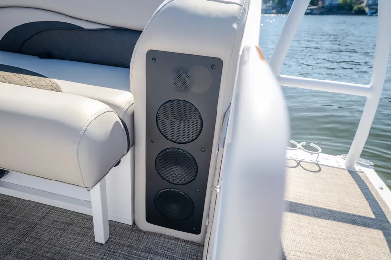 Slide: The Image of Luxury seating and speaker system on 2026 JC Sporttoon 26TT boat by the water. - 15