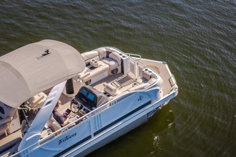 Slide: The Image of 2026 JC Sporttoon 26TT pontoon boat cruising on calm water, featuring spacious seating and canopy. - 56