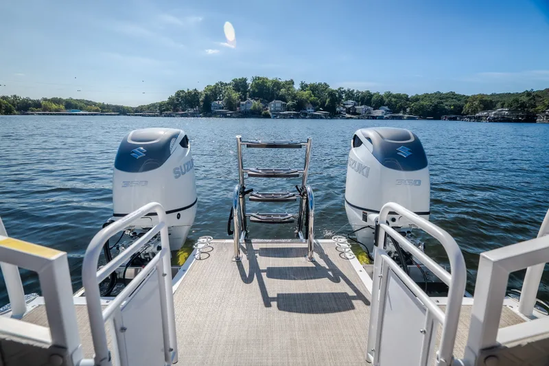 Slide: The Image of Pontoon boat "JC Sporttoon 26TT" with dual Suzuki engines on a serene lake. - 47