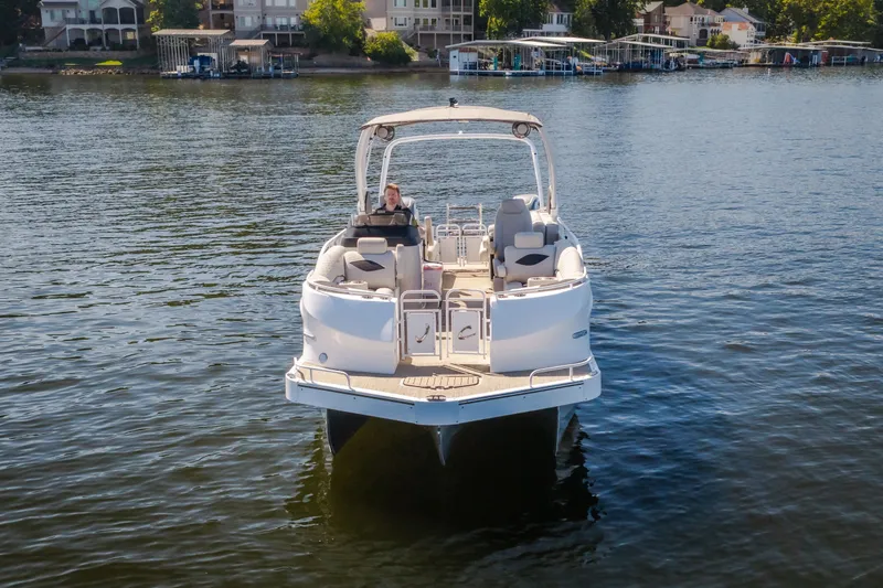 Slide: The Image of 2026 JC Sporttoon 26TT pontoon boat on a serene lake, with waterfront homes in the background. - 2