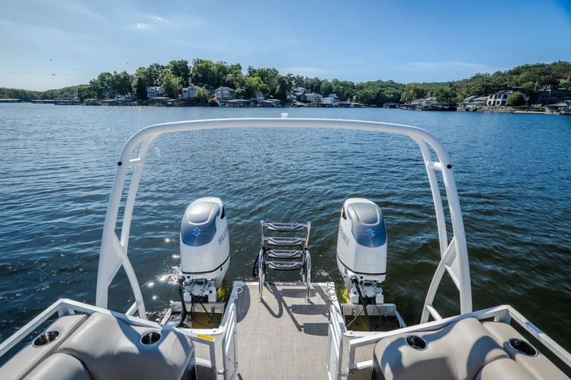 Slide: The Image of Pontoon boat JC Sporttoon 26TT 2026 on a serene lake with dual engines. - 6