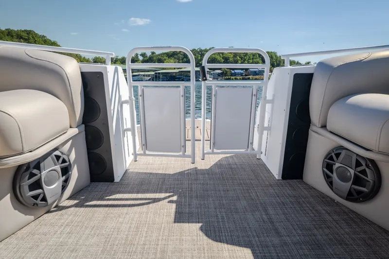 Slide: The Image of 2026 JC Sporttoon 26TT pontoon boat interior with speakers and seating, overlooking a serene lake. - 27