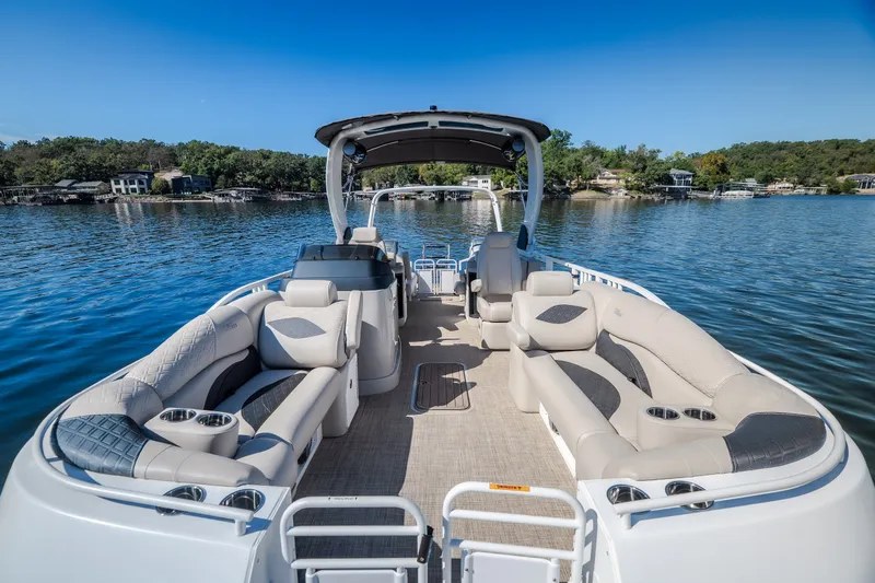 Slide: The Image of 2026 JC Sporttoon 26TT pontoon boat on a serene lake with luxurious seating. - 29