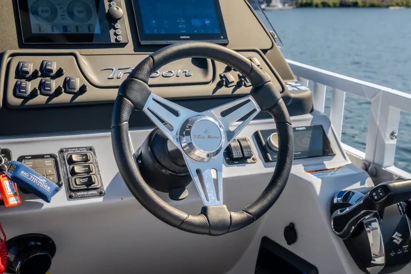 Slide: The Image of Steering wheel and dashboard of 2026 JC Sporttoon 26TT boat on water. - 34
