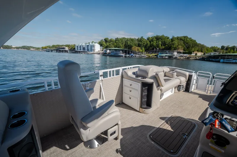 Slide: The Image of Luxurious 2026 JC Sporttoon 26TT pontoon boat interior with plush seating on a scenic lake. - 18