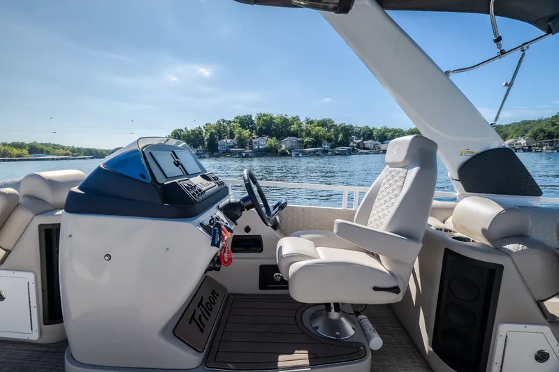 Slide: The Image of 2026 JC Sporttoon 26TT boat interior with luxurious seating and modern dashboard on a sunny lake. - 39