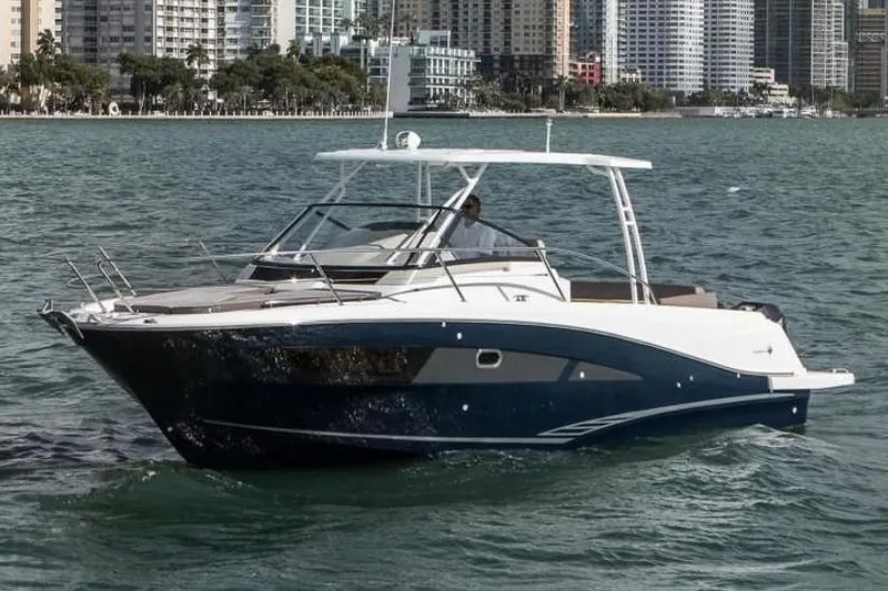 The Image of 2019 Jeanneau Leader 10.5 boat cruising near city skyline. - 0