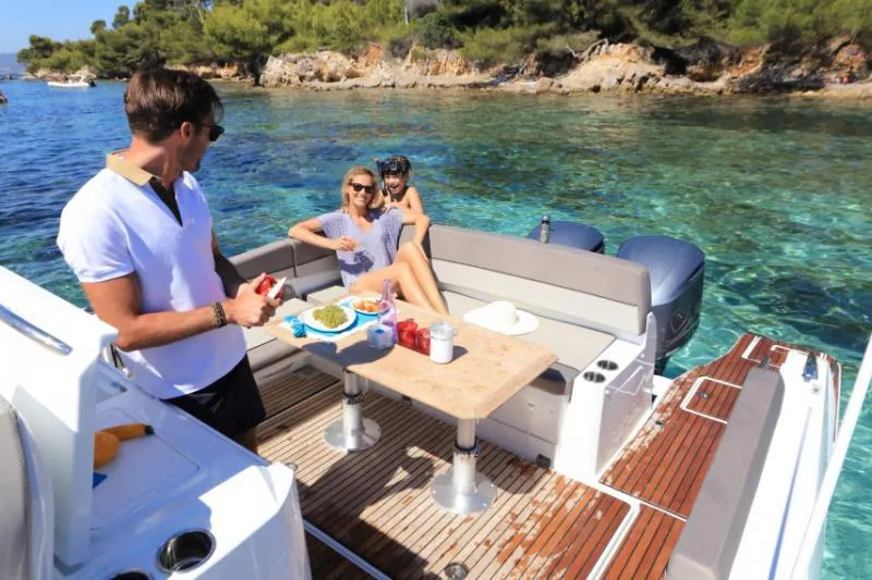 Slide: The Image of Manufacturer Provided Image: People enjoying a meal on a 2019 Jeanneau Leader 10.5 boat in clear waters. - 10