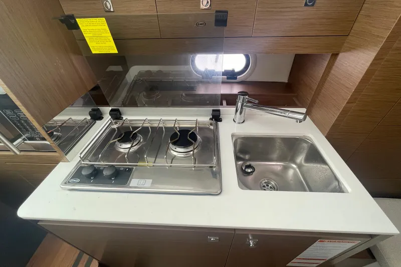 Slide: The Image of Compact kitchen area in a 2019 Jeanneau Leader 10.5 boat with stove and sink. - 15