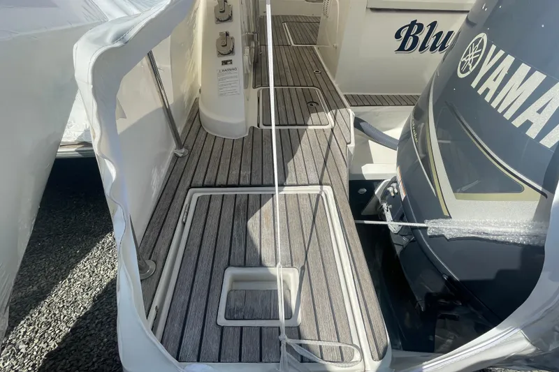 Slide: The Image of 2019 Jeanneau Leader 10.5 boat deck with wood finish and engine detail. - 24