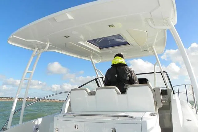 Slide: The Image of Manufacturer Provided Image: 2019 Jeanneau Leader 10.5 boat with a person navigating on open water. - 8