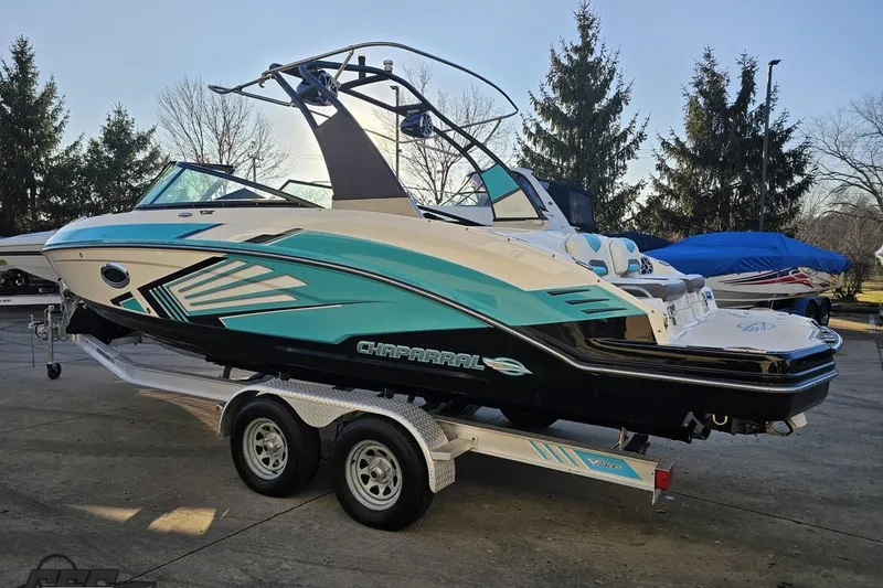 Slide: The Image of 2016 Chaparral Vortex 243 VRX boat on trailer, teal and black design, parked outdoors. - 26