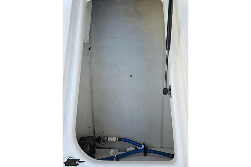 Slide: The Image of 2016 Chaparral Vortex 243 VRX storage compartment with hydraulic lift and blue tubing. - 56