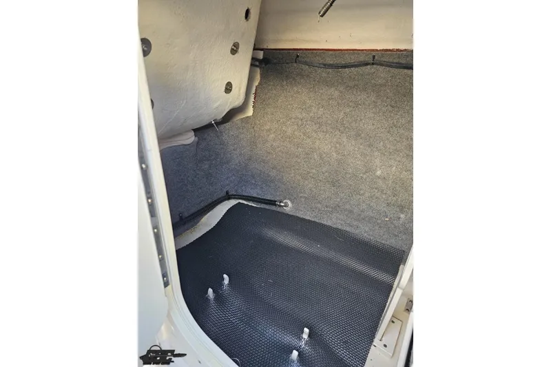 Slide: The Image of 2016 Chaparral Vortex 243 VRX interior storage compartment with carpeted walls and textured flooring. - 66