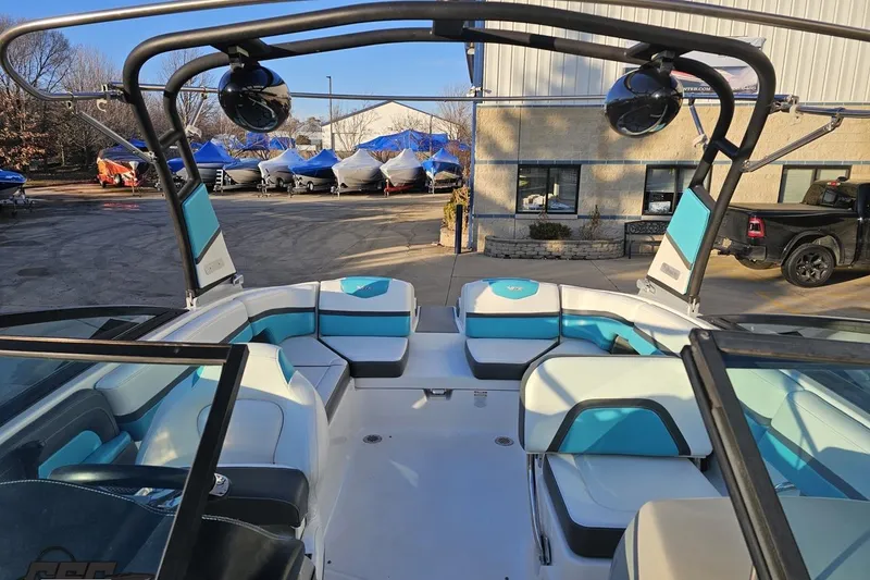 Slide: The Image of 2016 Chaparral Vortex 243 VRX boat interior with blue and white seating, docked outdoors. - 81