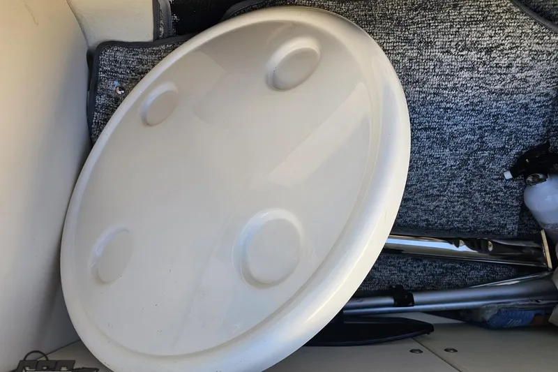 Slide: The Image of 2016 Chaparral Vortex 243 VRX interior with round table and carpeted flooring. - 89