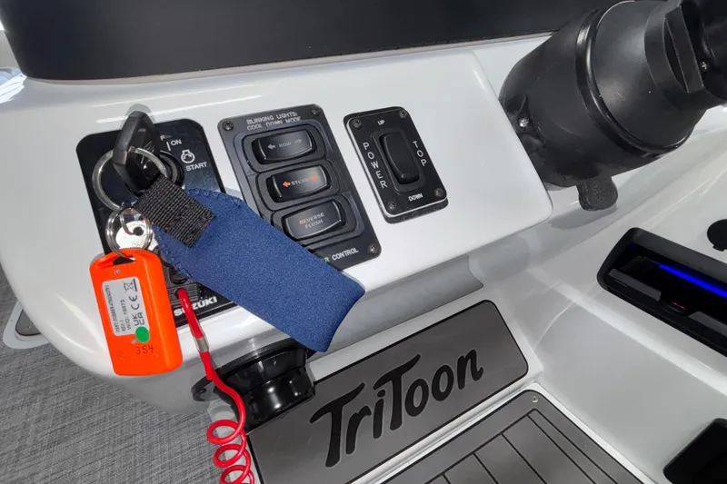 Slide: The Image of Control panel of 2026 JC Neptoon 25TT Sport boat with key and switches. - 26