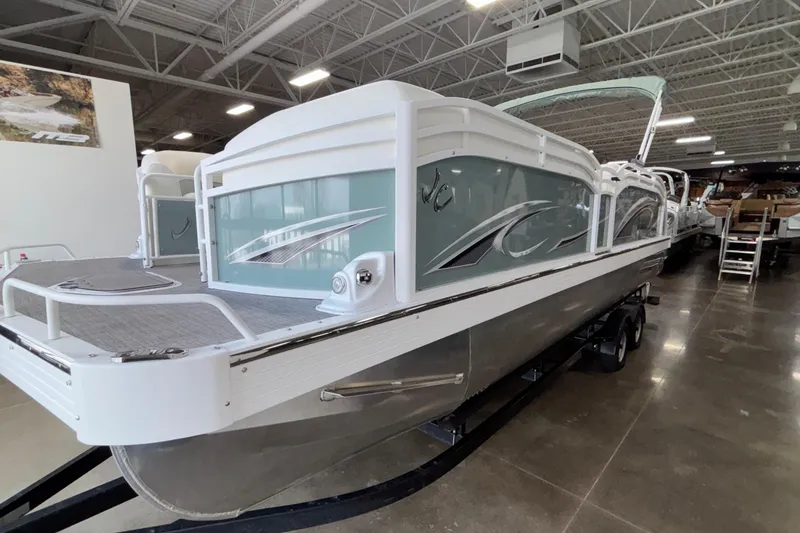 Slide: The Image of 2026 JC Neptoon 25TT Sport pontoon boat displayed indoors on a trailer. - 52