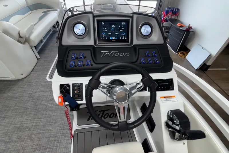 Slide: The Image of 2026 JC Neptoon 25TT Sport boat dashboard with steering wheel and control panel. - 25