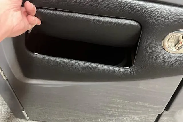 Slide: The Image of Hand opening storage compartment in 2026 MONACO 235SFL vehicle interior. - 11