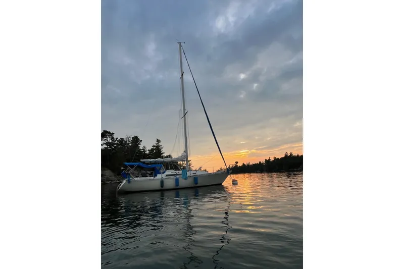 Slide: The Image of 1984 C&C 35-3 sailboat anchored at sunset on a tranquil lake. - 10