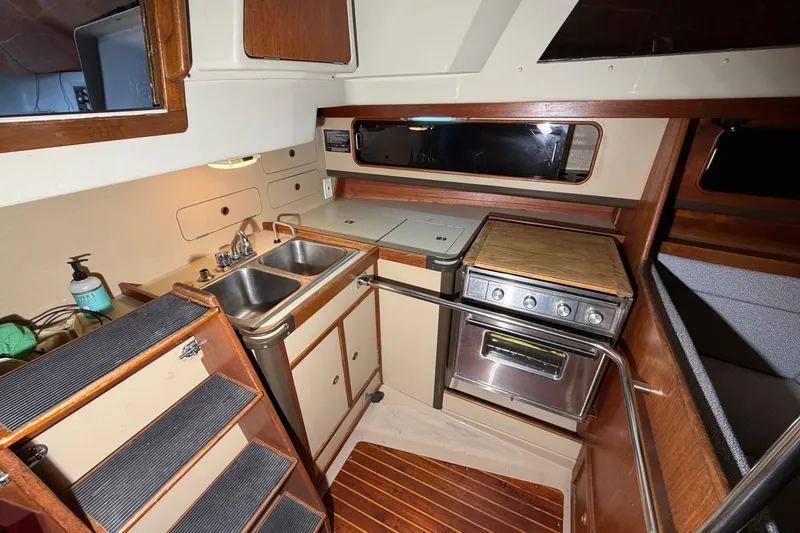 Slide: The Image of 1984 C&C 35-3 yacht interior kitchen with sink, stove, and wooden cabinetry. - 16