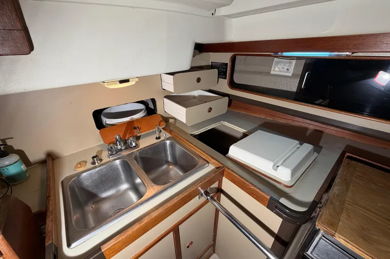 Slide: The Image of 1984 C&C 35-3 yacht galley with dual sinks, storage, and countertop. - 18