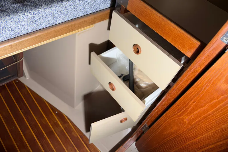 Slide: The Image of 1984 C&C 35-3 sailboat interior with open wooden drawers and striped flooring. - 30