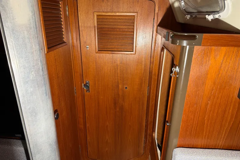 Slide: The Image of Wooden interior of 1984 C&C 35-3 sailboat, featuring a door and storage area. - 31