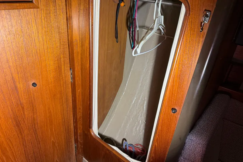 Slide: The Image of Wooden closet interior on 1984 C&C 35-3 sailboat with hangers and wiring. - 32